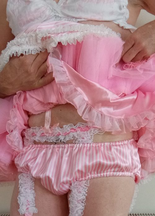 Sissy showing off her pink panties, stockings and suspenders